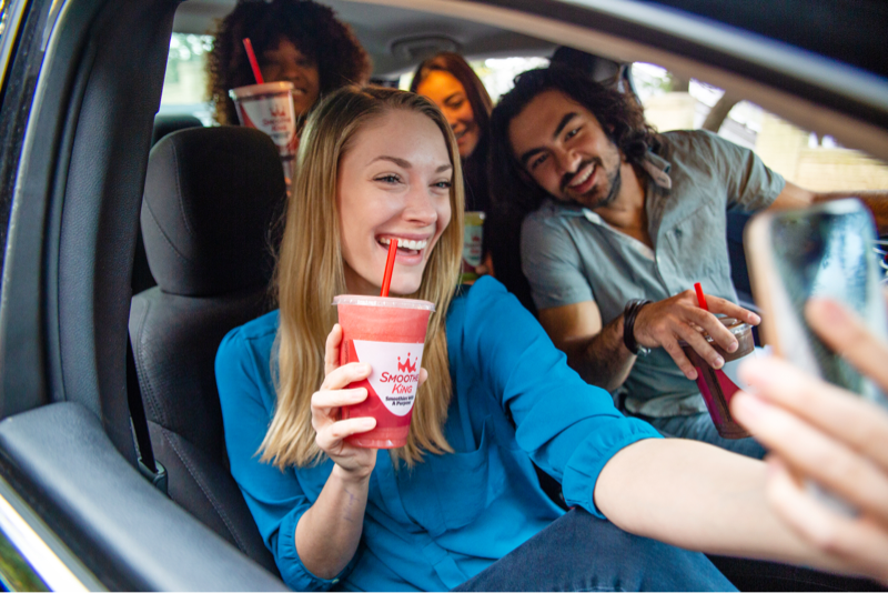 Friends taking a selfie in a car with their Smoothie King drinks