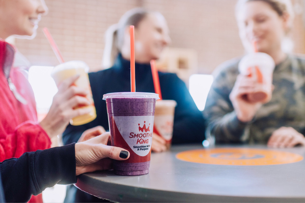A group of women drinking the best fruit smoothies and veggie smoothies at a table at Smoothie King